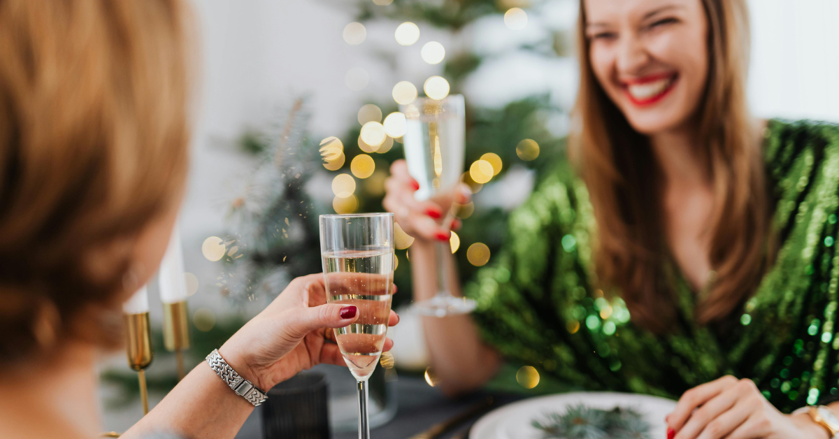 Festive women cheers with Idaho wine by Christmas tree
