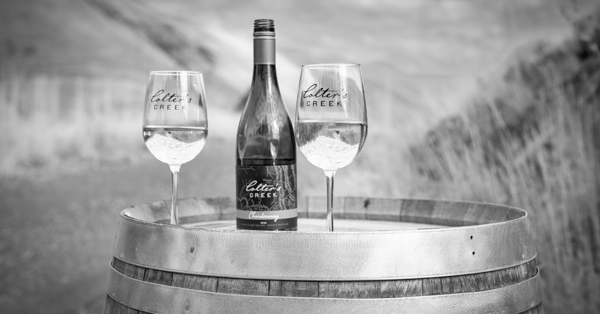 Colter's Creek Wine bottle and glasses on barrel