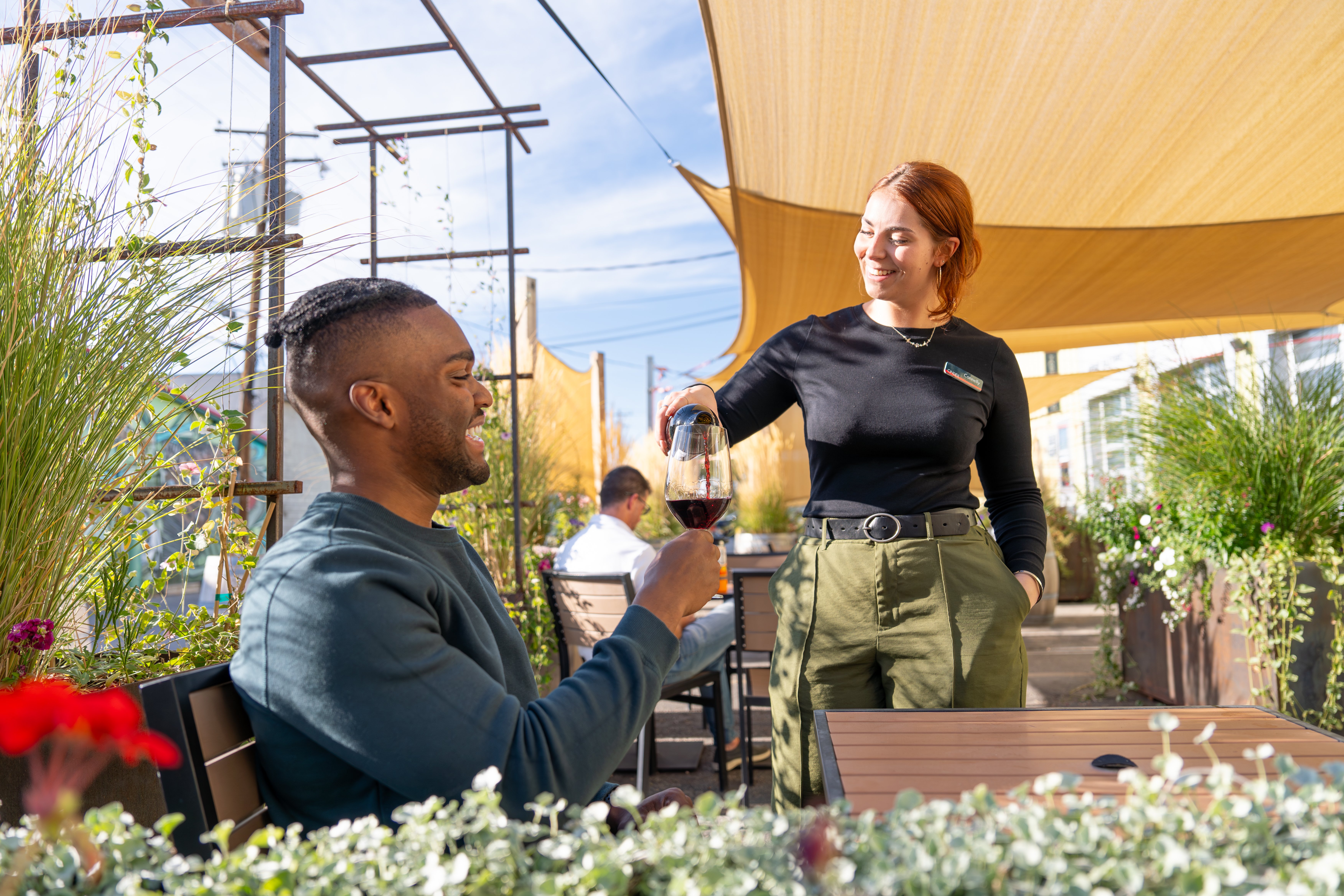 Idaho tasting room staff pouring man on patio Idaho wine