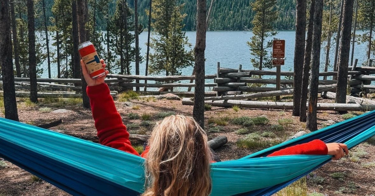 Woman drinking canned wine while camping